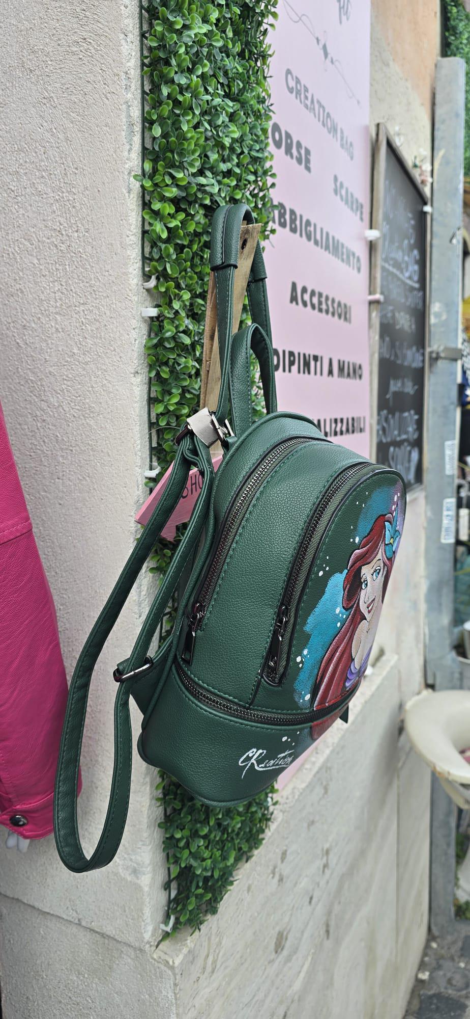 Zainetto Dipinto a Mano – Ariel La Sirenetta – Zaino Unico e Personalizzato *Descrizione:* 🎨 Zainetto artigianale dipinto interamente a mano, ispirato alla magia della Sirenetta! Il soggetto principale è Ariel, con colori intensi, dettagli curati e uno stile fiabesco perfetto per chi ama il mare e le storie incantate. 👜 *Caratteristiche:* • Realizzato in pelle/ecopelle di alta qualità • Dipinto a mano con colori acrilici professionali, resistenti e durevoli • Spazioso, comodo, con tasche interne e chiusur