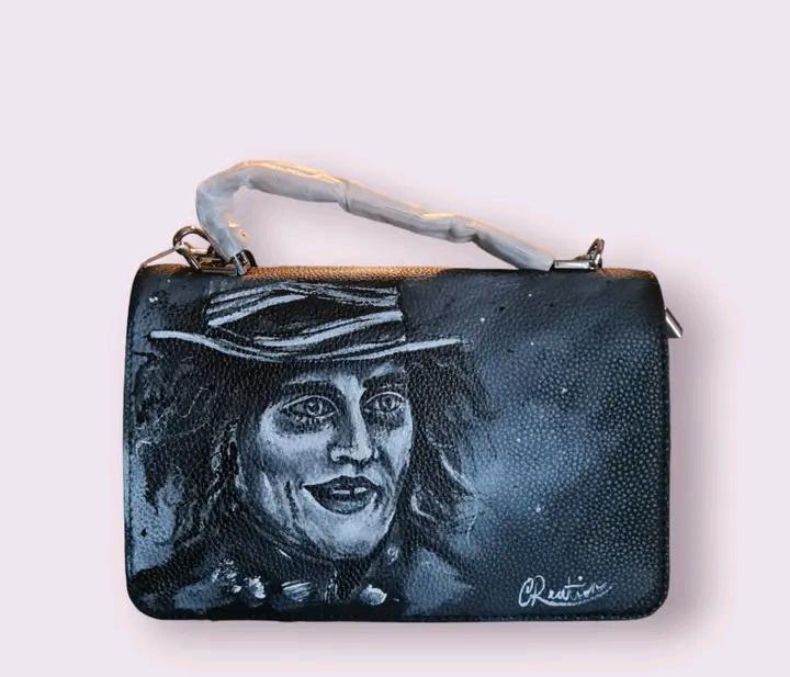Borsa Dipinta a Mano - Il Cappellaio Matto | Alice nel Paese delle Meraviglie | Accessorio Unico ✨ Un tocco di follia e magia per il tuo stile! ✨ Questa borsa unica è dipinta a mano con colori acrilici resistenti e raffigura il Cappellaio Matto, uno dei personaggi più iconici e stravaganti di Alice nel Paese delle Meraviglie! Un accessorio perfetto per gli amanti del mondo Disney e per chi vuole aggiungere un tocco di originalità e fantasia ai propri outfit