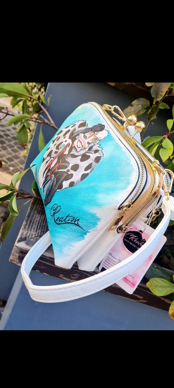 Borsa Dipinta a Mano Crudelia Demon - Accessorio Unico e Personalizzato - Stile Vintage e Raffinato Descrizione: Aggiungi un tocco di personalità al tuo look con questa borsa artigianale dipinta a mano, ispirata al personaggio iconico di Crudelia Demon. Ogni borsa è un’opera unica, realizzata con cura e passione, e rappresenta l'essenza audace e sofisticata della famosa villain