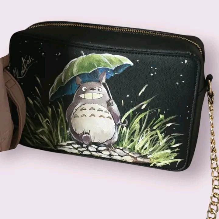 *Borsa Dipinta a Mano – Totoro 🦝🌿* Aggiungi un tocco di *magia* e *naturalità* al tuo look con questa *borsa dipinta a mano* raffigurante *Totoro*, il celebre personaggio del famoso cartone animato giapponese! 🎨 Realizzata con *colori acrilici di alta qualità*, questa borsa è perfetta per chi ama i personaggi animati e desidera portare con sé un pezzo di *naturalezza* e *gioia*. 🌟 Ogni borsa è un pezzo unico, dipinto con cura e attenzione ai dettagli per rendere *Totoro* ancora più affascinante e specia