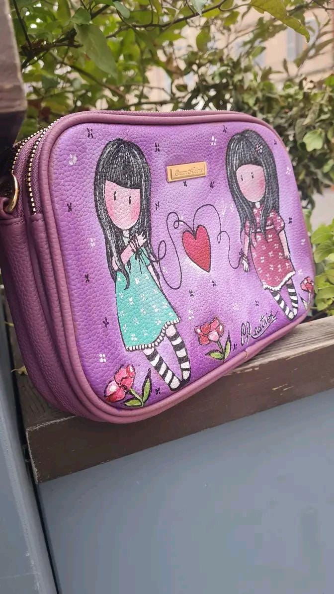 Borsa Dipinta a Mano - Il Filo Rosso che ci Unisce | Simbolo di Connessione e Amicizia ✨ Un accessorio unico, simbolo di legami indissolubili! ✨ Questa borsa speciale è dipinta a mano con colori acrilici resistenti e raffigura due bambine unite da un filo rosso con un cuore al centro, simbolo di connessione, amicizia e amore destinato. Perfetta per chi crede nel legame invisibile che unisce le anime, rendendole inseparabili.