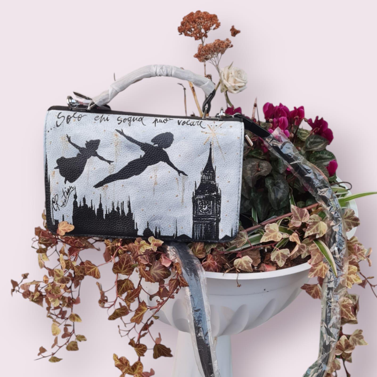 Lasciati trasportare nel mondo magico di Neverland con questa borsa dipinta a mano, raffigurante Peter Pan che vola! Con la frase ispiratrice "Solo chi sogna può volare", questa borsa è un invito a credere nei propri sogni e ad affrontare ogni giorno con un pizzico di magia. Un accessorio unico, perfetto per chi cerca un mix di arte, fantasia e funzionalità. 🧩 *Coordinabile su richiesta:* È possibile ordinare *un portafoglio o un giacchetto perfettamente abbinato* con lo stesso stile e soggetto ! Caratteri