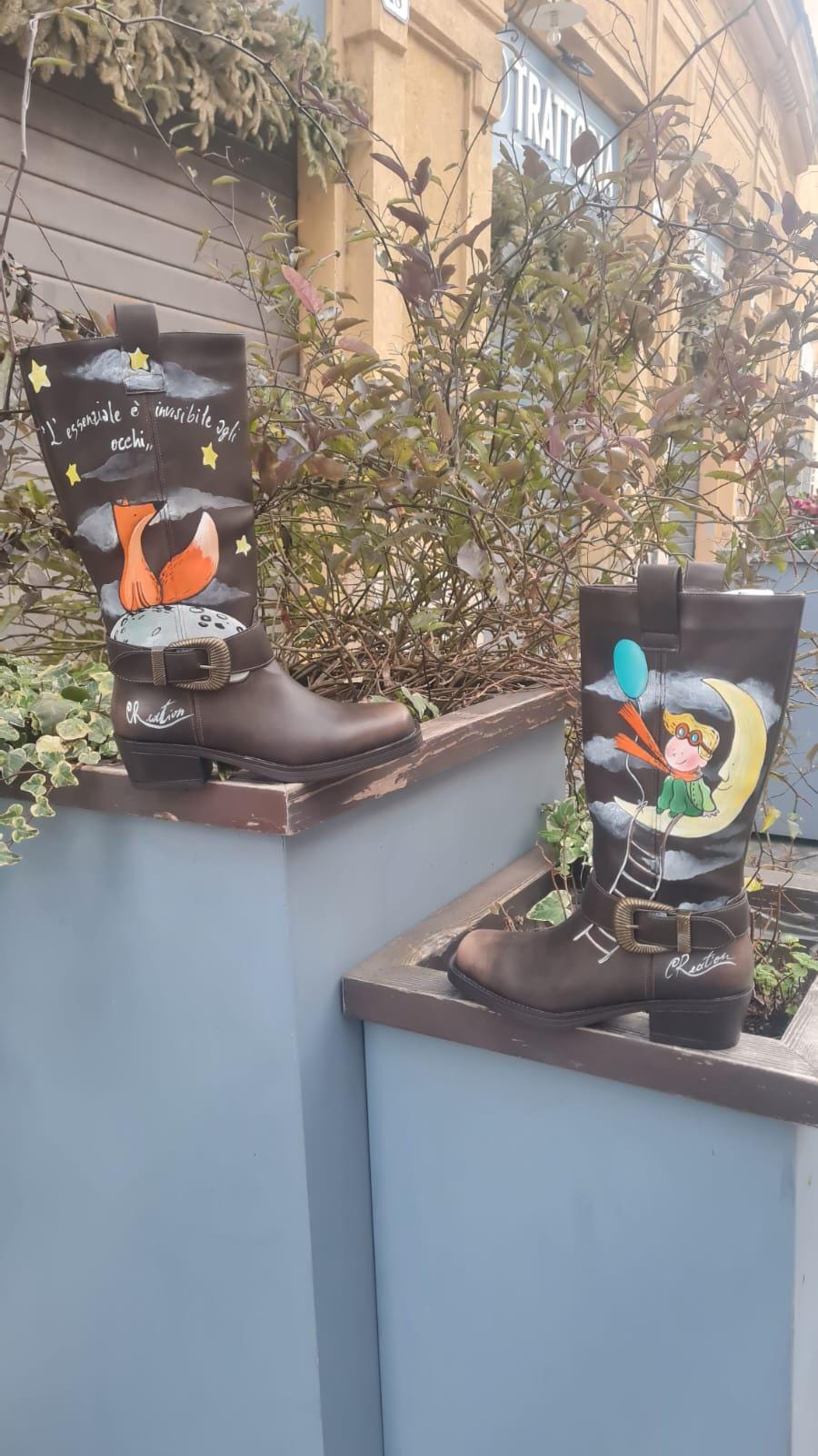 Stivali dipinti a mano - Il Piccolo Principe 🧩 *Coordinabile su richiesta:* È possibile ordinare *un portafoglio , una borsa o un giacchetto perfettamente abbinato* con lo stesso stile e soggetto ! Porta con te la magia del Piccolo Principe con questi stivali unici, dipinti a mano con cura e passione. Il design raffigura il piccolo principe seduto su una luna, mentre la sua fidata amica, la volpe, è disegnata su un pianeta lontano