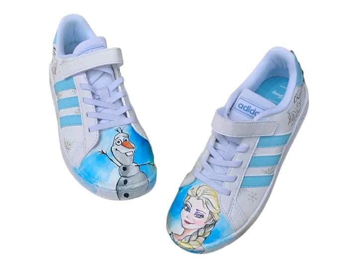 ❄️ Scarpe Adidas Dipinte a Mano – Tema Frozen 👟🎨 Porta la magia di Arendelle ai tuoi piedi con queste scarpe Adidas personalizzate a mano ispirate a Frozen, il celebre cartone Disney! Un paio unico ed esclusivo, realizzato con passione e materiali di alta qualità, ideale per chi ama Elsa, Anna e l’incanto dell’inverno! 💙✨ 🧩 *Coordinabile su richiesta:* È possibile ordinare *un portafoglio , una borsa o un giacchetto perfettamente abbinato* con lo stesso stile e soggetto ! 🖌️ Dettagli del prodotto: - Sc