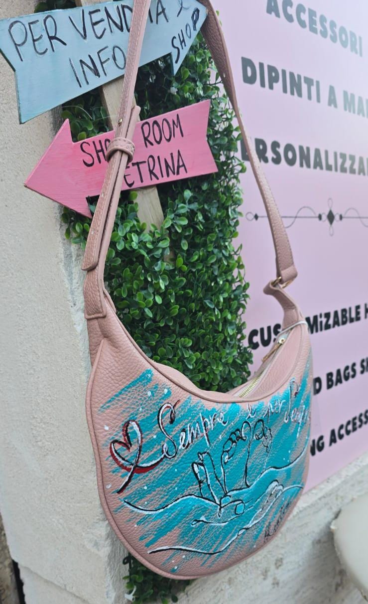 Borsa dipinta a mano – “Sempre e per sempre” 🎨 Borsa artigianale realizzata interamente a mano, con un toccante soggetto: due mani che reggono due piccoli piedini di un bambino, simbolo d’amore eterno e protezione. 👜 Il messaggio "Sempre e per sempre" rende questo accessorio un regalo speciale per mamme, neo-genitori o per celebrare un legame profondo. 📐 Misura: borsa capiente 🧵 Materiale: ecopelle/pelle 💡 Possibilità di richiedere la personalizzazione del soggetto o una frase diversa. 👟 Coordinabile 