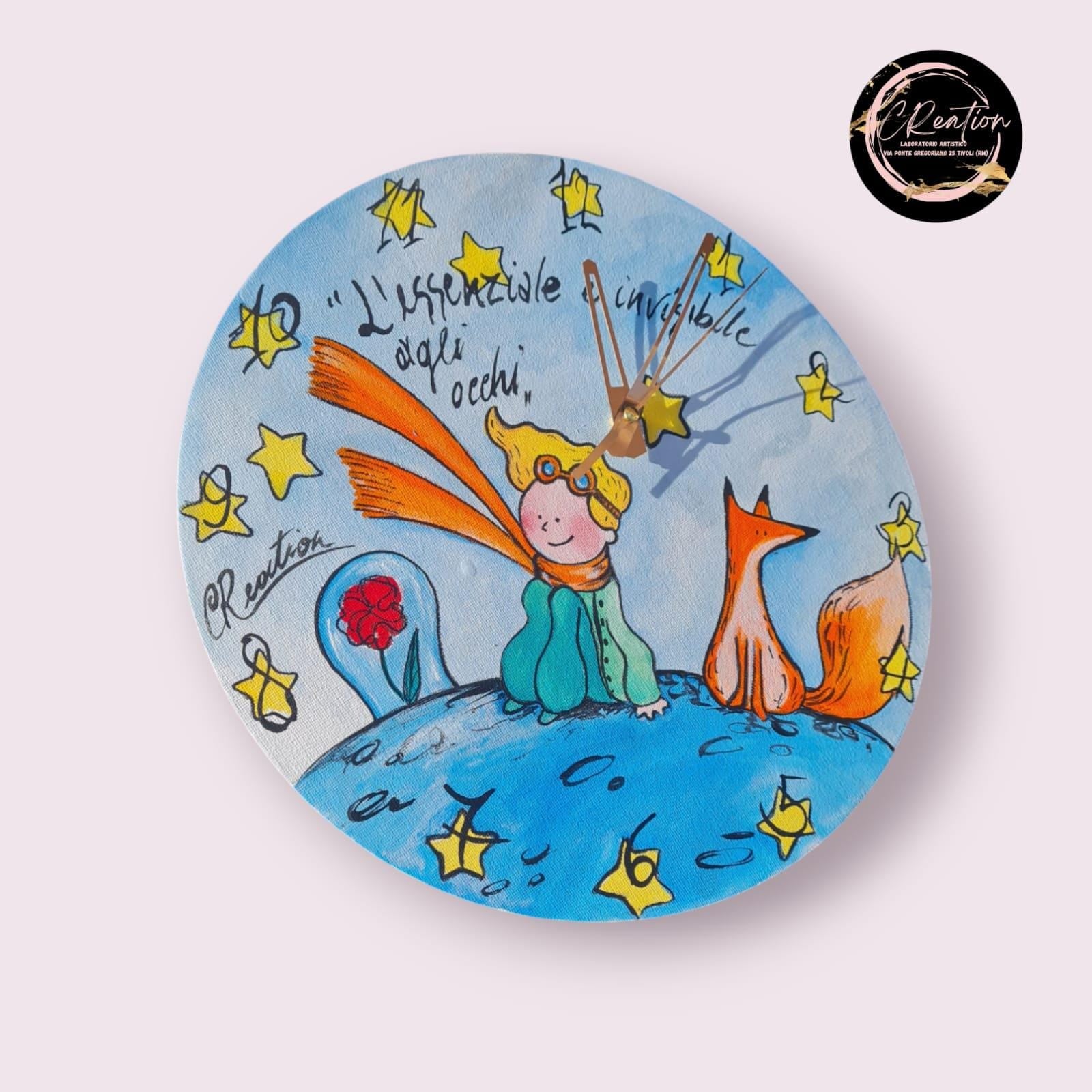 Orologio da Parete Dipinto a Mano - Il Piccolo Principe - Accessorio Unico e Magico per la Tua Casa Descrizione: Aggiungi un tocco di poesia e magia alla tua casa con questo orologio da parete dipinto a mano, ispirato al celebre Piccolo Principe. Ogni dettaglio di questo orologio è realizzato con cura per catturare l’essenza senza tempo di questa storia, trasformando un semplice oggetto quotidiano in una vera e propria opera d’arte.