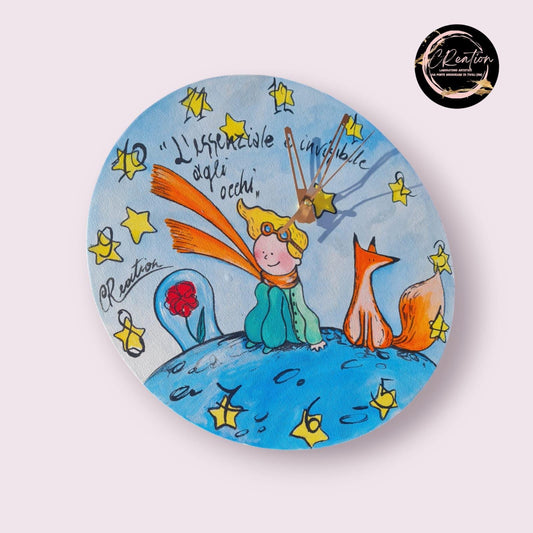 Orologio da Parete Dipinto a Mano - Il Piccolo Principe - Accessorio Unico e Magico per la Tua Casa Descrizione: Aggiungi un tocco di poesia e magia alla tua casa con questo orologio da parete dipinto a mano, ispirato al celebre Piccolo Principe. Ogni dettaglio di questo orologio è realizzato con cura per catturare l’essenza senza tempo di questa storia, trasformando un semplice oggetto quotidiano in una vera e propria opera d’arte.