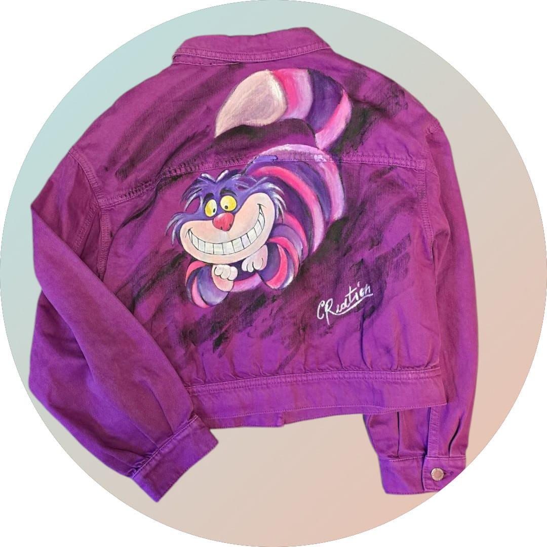 Giacca Donna Dipinta a Mano – Stregatto 🎨🐱👓 Un capo unico, ironico e ricco di magia! Questa giacca in jeans da donna taglia L è dipinta interamente a mano con colori acrilici professionali, e ha come soggetto l’inconfondibile Stregatto, il celebre gatto sorridente di Alice nel Paese delle Meraviglie. Ogni dettaglio è realizzato con cura artigianale: un mix perfetto tra stile, fantasia e creatività! 🌈✨ 🧩 *Coordinabile su richiesta:* È possibile ordinare *un portafoglio , una borsa perfettamente abbinato