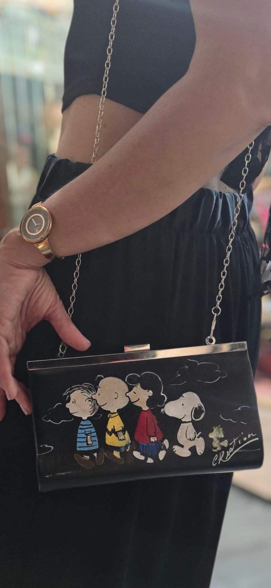 *Borsa Dipinta a Mano – Snoopy &amp; Friends 🐾🎨* Colorata, divertente e dal tocco unico! Questa *borsa in ecopelle* è dipinta interamente a mano e ha come soggetto principale *Snoopy* insieme agli altri personaggi iconici del mondo dei Peanuts. Perfetta per chi ama lo stile originale e vuole portare sempre con sé un tocco di tenerezza e allegria! 👜 *Dettagli del prodotto:* - Materiale: Ecopelle