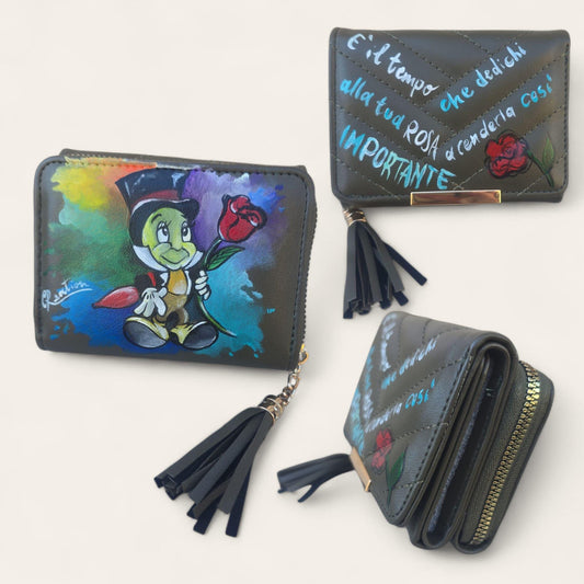 Portafoglio dipinto a mano – Grillo Parlante | Accessorio unico e personalizzabile | Idea regalo artigianale --- *📌 Descrizione* Portafoglio artigianale dipinto a mano con il soggetto del *Grillo Parlante*, ispirato al celebre cartone animato. Un pezzo unico realizzato con passione, perfetto per chi ama i personaggi classici dell’animazione. 🎨 Realizzato su ecopelle di alta qualità