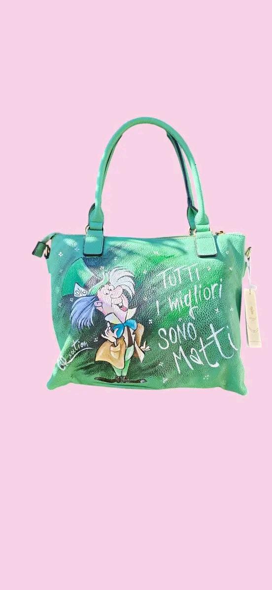 Borsa Dipinta a Mano con Cappellaio Matto - “Tutti i migliori sono matti” - Ecopelle - Personalizzabile 🧩 *Coordinabile su richiesta:* È possibile ordinare *un portafoglio o un giacchetto perfettamente abbinato* con lo stesso stile e soggetto ! Descrizione: Questa borsa dipinta a mano è un omaggio al famoso Cappellaio Matto, personaggio iconico del celebre cartone animato.