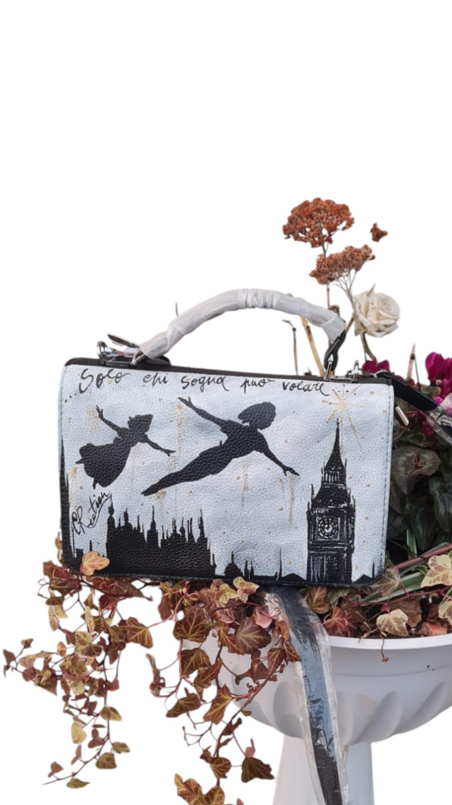 Lasciati trasportare nel mondo magico di Neverland con questa borsa dipinta a mano, raffigurante Peter Pan che vola! Con la frase ispiratrice "Solo chi sogna può volare", questa borsa è un invito a credere nei propri sogni e ad affrontare ogni giorno con un pizzico di magia. Un accessorio unico, perfetto per chi cerca un mix di arte, fantasia e funzionalità. 🧩 *Coordinabile su richiesta:* È possibile ordinare *un portafoglio o un giacchetto perfettamente abbinato* con lo stesso stile e soggetto ! Caratteri