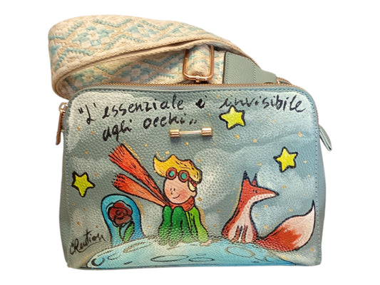 Borsa dipinta a mano – Il Piccolo Principe – Borsa artigianale unica personalizzata *Descrizione:* Borsa in *pelle/ecopelle* dipinta a mano con soggetto *Il Piccolo Principe*, uno dei personaggi più amati di sempre. Ogni borsa è realizzata con *colori acrilici professionali*, resistenti nel tempo e pensati per accompagnarti ogni giorno con un tocco artistico e poetico.