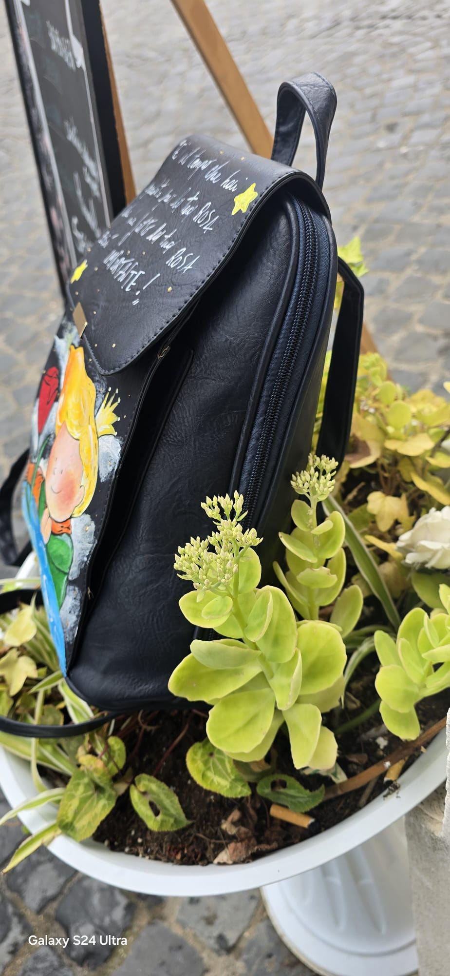 *Zaino nero dipinto a mano – Il Piccolo Principe | Citazione iconica ✨🌹* 🧩 *Coordinabile su richiesta:* È possibile ordinare *un portafoglio o un giacchetto perfettamente abbinato* con lo stesso stile e soggetto ! Zainetto in ecopelle nera con illustrazione realizzata a mano ispirata al celebre personaggio de *Il Piccolo Principe*, accanto alla sua rosa. Sul patta è riportata la frase più amata del libro