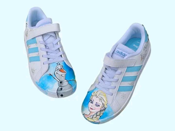 ❄️ Scarpe Adidas Dipinte a Mano – Tema Frozen 👟🎨 Porta la magia di Arendelle ai tuoi piedi con queste scarpe Adidas personalizzate a mano ispirate a Frozen, il celebre cartone Disney! Un paio unico ed esclusivo, realizzato con passione e materiali di alta qualità, ideale per chi ama Elsa, Anna e l’incanto dell’inverno! 💙✨ 🧩 *Coordinabile su richiesta:* È possibile ordinare *un portafoglio , una borsa o un giacchetto perfettamente abbinato* con lo stesso stile e soggetto ! 🖌️ Dettagli del prodotto: - Sc
