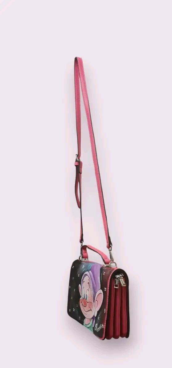 Borsa Dipinta a Mano con Cucciolo dei Sette Nani - Borsa Unica in Ecopelle, Personalizzabile, Regalo per Amanti dei Cartoni 🧩 *Coordinabile su richiesta:* È possibile ordinare *un portafoglio o un giacchetto perfettamente abbinato* con lo stesso stile e soggetto ! Descrizione: Questa borsa dipinta a mano è ispirata al simpatico cucciolo dei Sette Nani, celebre personaggio del cartone animato Biancaneve e i sette nani. Realizzata in ecopelle di alta qualità, la borsa presenta un’illustrazione unica che catt