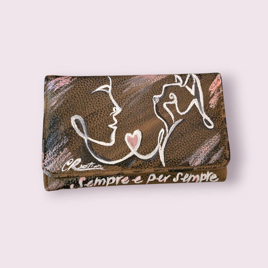 Portafoglio Dipinto a Mano – Sempre è per sempre 🎨 Portafoglio Dipinto a Mano 🎨 Porta con te un’opera d’arte con questo portafoglio in ecopelle, dipinto a mano con colori acrilici di alta qualità e ispirato all'amore per i propri animali. Un accessorio perfetto per chi ama il design artistico e gli oggetti unici. 📌 Dettagli Prodotto: ✔ Pezzo unico: Il prodotto in foto è stato venduto, ma verrà realizzato con lo stesso design su una borsa molto simile ✔ Materiale: Ecopelle ✔ Tecnica: Pittura acrilica a ma