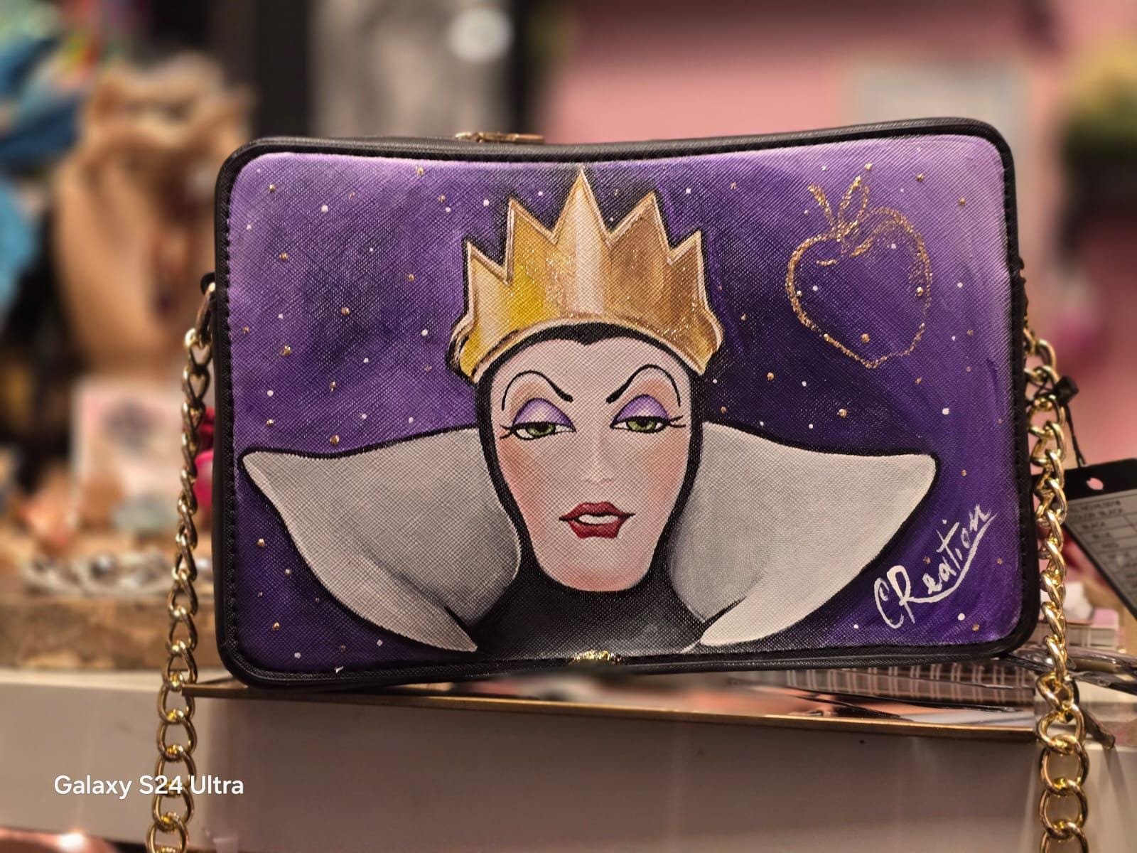 Borsa dipinta a mano ispirata alla Regina Grimilde Materiale: Ecopelle | Misure: 27 cm (lunghezza) x 8 cm (profondità) x 16 cm (altezza) 🧩 *Coordinabile su richiesta:* È possibile ordinare *un portafoglio o un giacchetto perfettamente abbinato* con lo stesso stile e soggetto