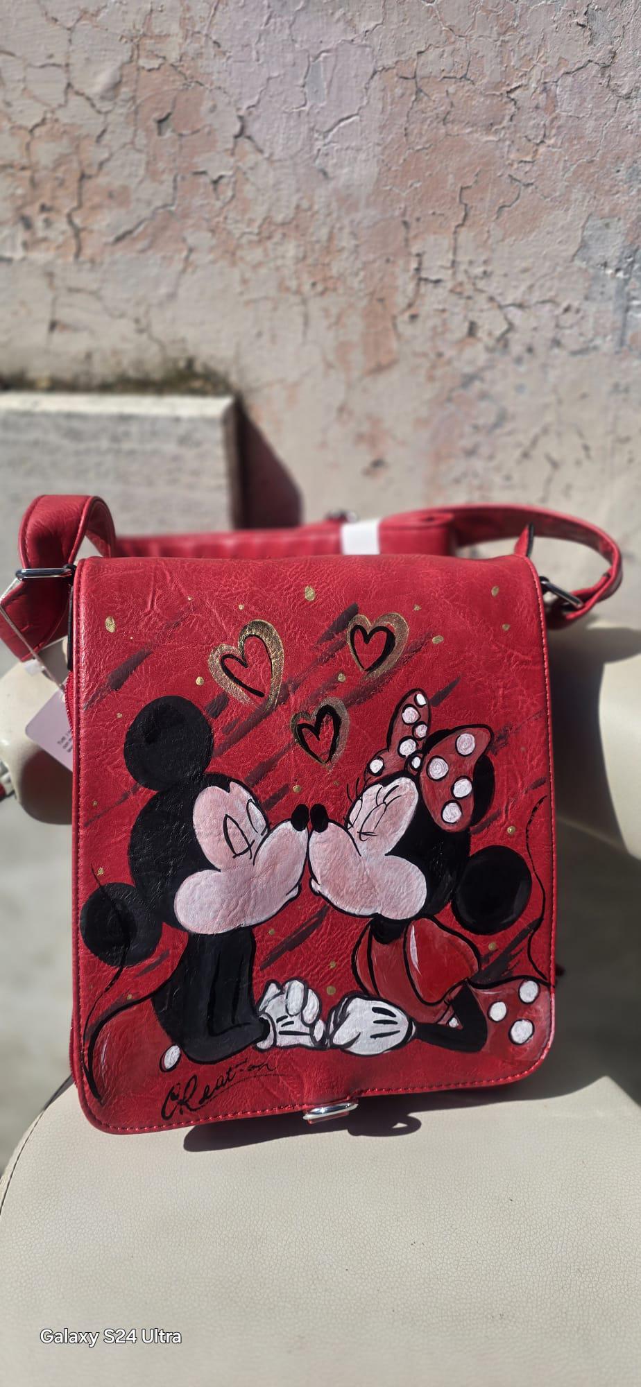 Borsa dipinta a mano – Minnie e Topolino che si baciano – Idea regalo romantica – Personalizzabile *Descrizione* ✨ Borsa unica e romantica, dipinta interamente a mano con il dolcissimo soggetto di Minnie e Topolino che si baciano 💕 Realizzata su base in pelle/ecopelle di alta qualità, resistente e capiente, perfetta per l’uso quotidiano o come idea regalo originale. I colori utilizzati sono acrilici professionali per tessuti, resistenti all’acqua e al tempo