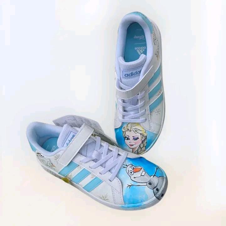 ❄️ Scarpe Adidas Dipinte a Mano – Tema Frozen 👟🎨 Porta la magia di Arendelle ai tuoi piedi con queste scarpe Adidas personalizzate a mano ispirate a Frozen, il celebre cartone Disney! Un paio unico ed esclusivo, realizzato con passione e materiali di alta qualità, ideale per chi ama Elsa, Anna e l’incanto dell’inverno! 💙✨ 🧩 *Coordinabile su richiesta:* È possibile ordinare *un portafoglio , una borsa o un giacchetto perfettamente abbinato* con lo stesso stile e soggetto ! 🖌️ Dettagli del prodotto: - Sc