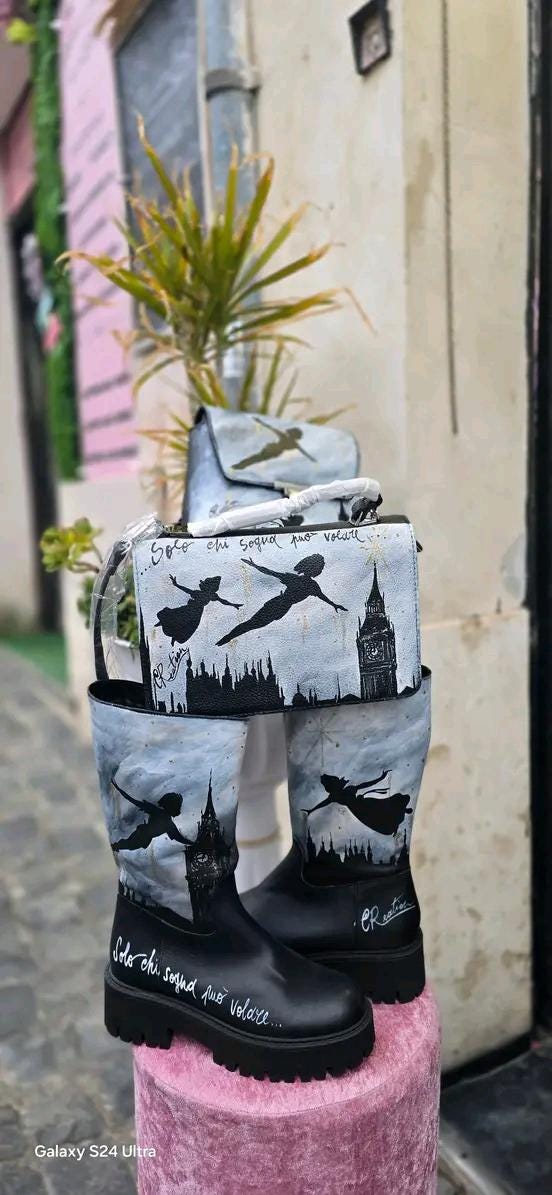 Stivale Dipinto a Mano con Personaggi di Peter Pan - Solo chi sogna può volare + Promo Stivale + Borsa Coordinata Aggiungi un tocco di magia al tuo look con questi stivali dipinti a mano, ispirati al mondo incantato di Peter Pan! Ogni paio è realizzato con cura e dettagli, con due personaggi di Peter Pan che volano nel cielo, accompagnati da uno sfondo mozzafiato. La frase "Solo chi sogna può volare" rende questo prodotto ancora più speciale, perfetto per chi ama sognare e vivere ogni giorno come una nuova 