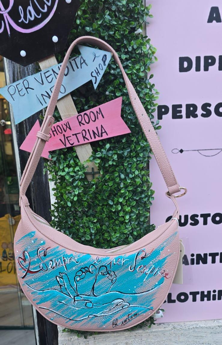 Borsa dipinta a mano – “Sempre e per sempre” 🎨 Borsa artigianale realizzata interamente a mano, con un toccante soggetto: due mani che reggono due piccoli piedini di un bambino, simbolo d’amore eterno e protezione. 👜 Il messaggio "Sempre e per sempre" rende questo accessorio un regalo speciale per mamme, neo-genitori o per celebrare un legame profondo. 📐 Misura: borsa capiente 🧵 Materiale: ecopelle/pelle 💡 Possibilità di richiedere la personalizzazione del soggetto o una frase diversa. 👟 Coordinabile 