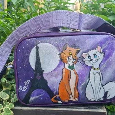 "Borsa Aristogatti dipinta a mano in ecopelle | Lavabile fino a 40°C | Unica e artigianale" 🧩 *Coordinabile su richiesta:* È possibile ordinare *un portafoglio o un giacchetto perfettamente abbinato* con lo stesso stile e soggetto ! Descrizione: Questa borsa artigianale è un omaggio ai dolcissimi Aristogatti! Dipinta a mano con colori acrilici di alta qualità su ecopelle resistente, è l'accessorio perfetto per gli amanti dell'arte e dei classici Disney. La foto mostrata si riferisce a un prodotto già vendu