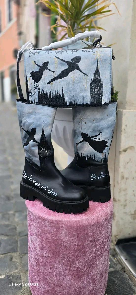 Stivale Dipinto a Mano con Personaggi di Peter Pan - Solo chi sogna può volare + Promo Stivale + Borsa Coordinata Aggiungi un tocco di magia al tuo look con questi stivali dipinti a mano, ispirati al mondo incantato di Peter Pan! Ogni paio è realizzato con cura e dettagli, con due personaggi di Peter Pan che volano nel cielo, accompagnati da uno sfondo mozzafiato. La frase "Solo chi sogna può volare" rende questo prodotto ancora più speciale, perfetto per chi ama sognare e vivere ogni giorno come una nuova 