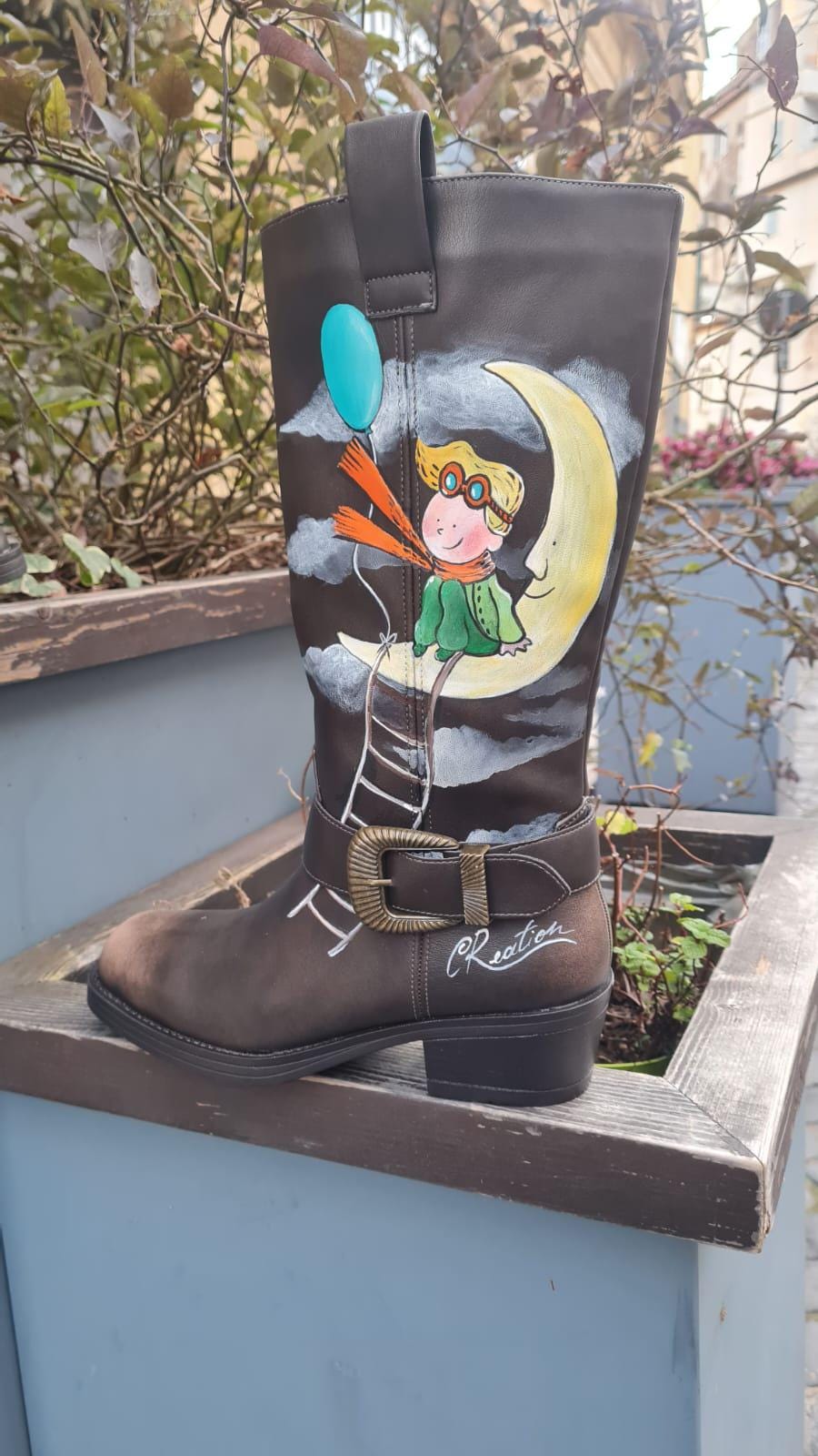 Stivali dipinti a mano - Il Piccolo Principe 🧩 *Coordinabile su richiesta:* È possibile ordinare *un portafoglio , una borsa o un giacchetto perfettamente abbinato* con lo stesso stile e soggetto ! Porta con te la magia del Piccolo Principe con questi stivali unici, dipinti a mano con cura e passione. Il design raffigura il piccolo principe seduto su una luna, mentre la sua fidata amica, la volpe, è disegnata su un pianeta lontano