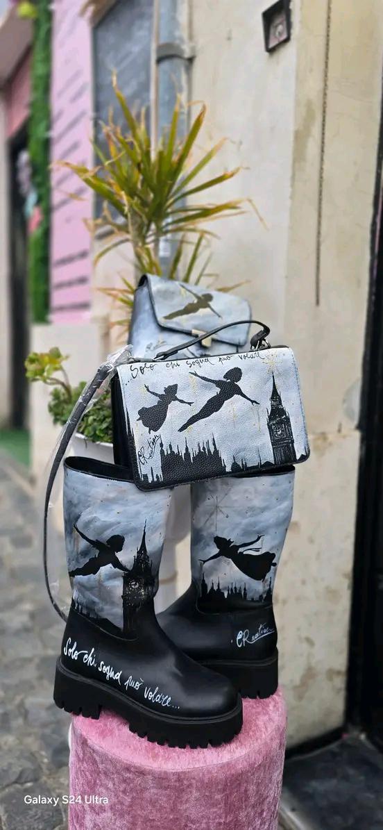 Stivale Dipinto a Mano con Personaggi di Peter Pan - Solo chi sogna può volare + Promo Stivale + Borsa Coordinata Aggiungi un tocco di magia al tuo look con questi stivali dipinti a mano, ispirati al mondo incantato di Peter Pan! Ogni paio è realizzato con cura e dettagli, con due personaggi di Peter Pan che volano nel cielo, accompagnati da uno sfondo mozzafiato. La frase "Solo chi sogna può volare" rende questo prodotto ancora più speciale, perfetto per chi ama sognare e vivere ogni giorno come una nuova 