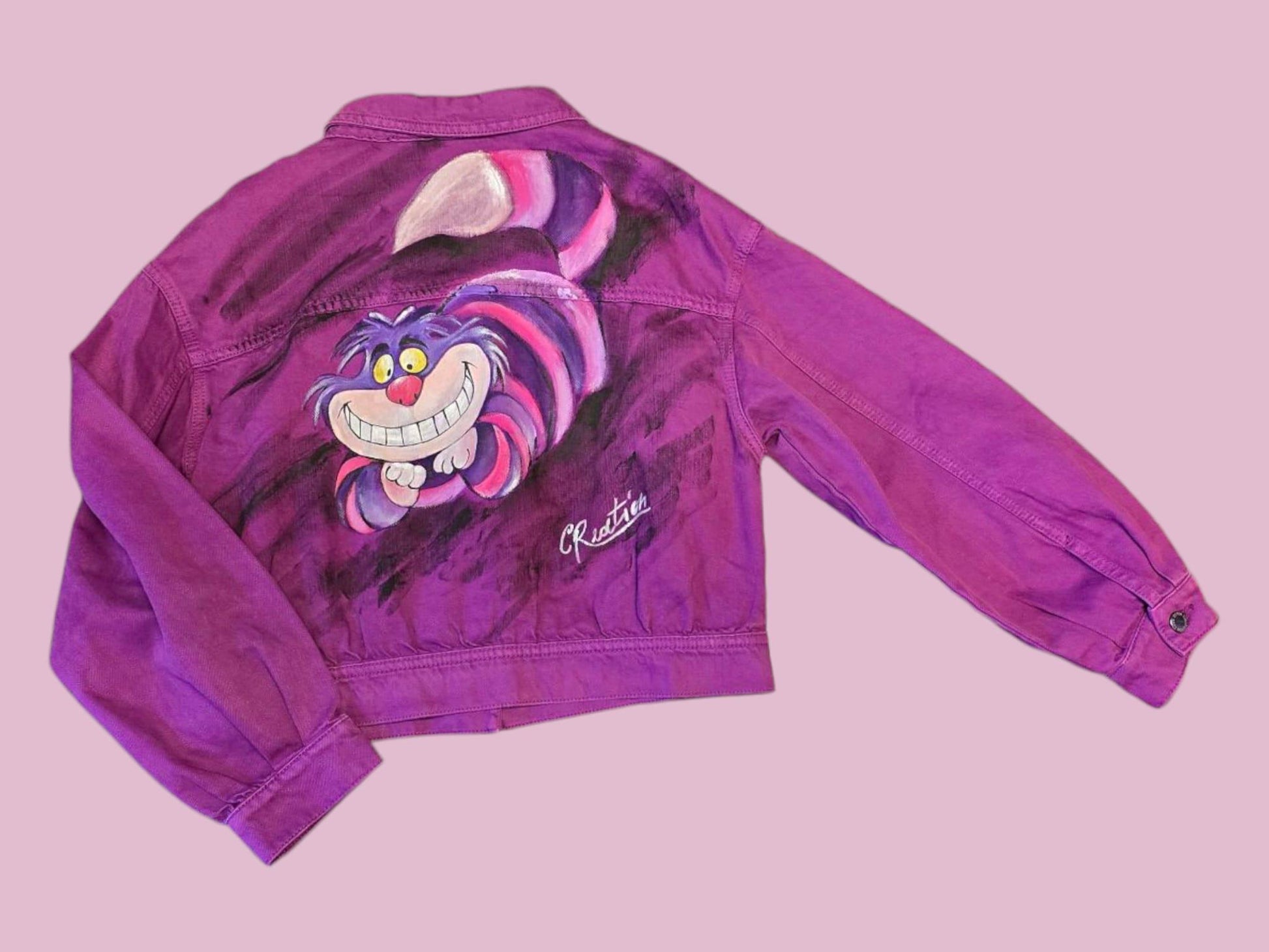 Giacca Donna Dipinta a Mano – Stregatto 🎨🐱👓 Un capo unico, ironico e ricco di magia! Questa giacca in jeans da donna taglia L è dipinta interamente a mano con colori acrilici professionali, e ha come soggetto l’inconfondibile Stregatto, il celebre gatto sorridente di Alice nel Paese delle Meraviglie. Ogni dettaglio è realizzato con cura artigianale: un mix perfetto tra stile, fantasia e creatività! 🌈✨ 🧩 *Coordinabile su richiesta:* È possibile ordinare *un portafoglio , una borsa perfettamente abbinato