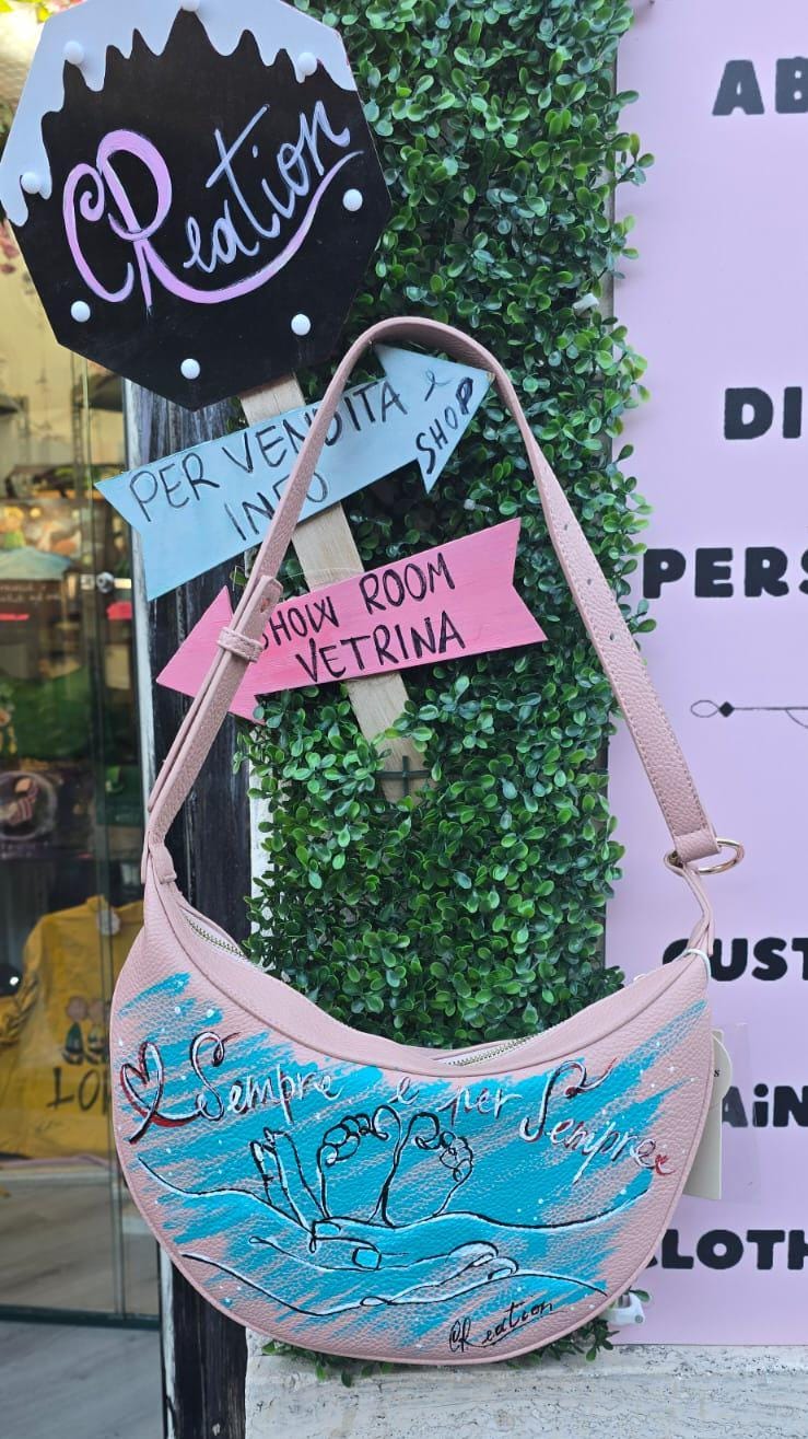 Borsa dipinta a mano – “Sempre e per sempre” 🎨 Borsa artigianale realizzata interamente a mano, con un toccante soggetto: due mani che reggono due piccoli piedini di un bambino, simbolo d’amore eterno e protezione. 👜 Il messaggio "Sempre e per sempre" rende questo accessorio un regalo speciale per mamme, neo-genitori o per celebrare un legame profondo. 📐 Misura: borsa capiente 🧵 Materiale: ecopelle/pelle 💡 Possibilità di richiedere la personalizzazione del soggetto o una frase diversa. 👟 Coordinabile 