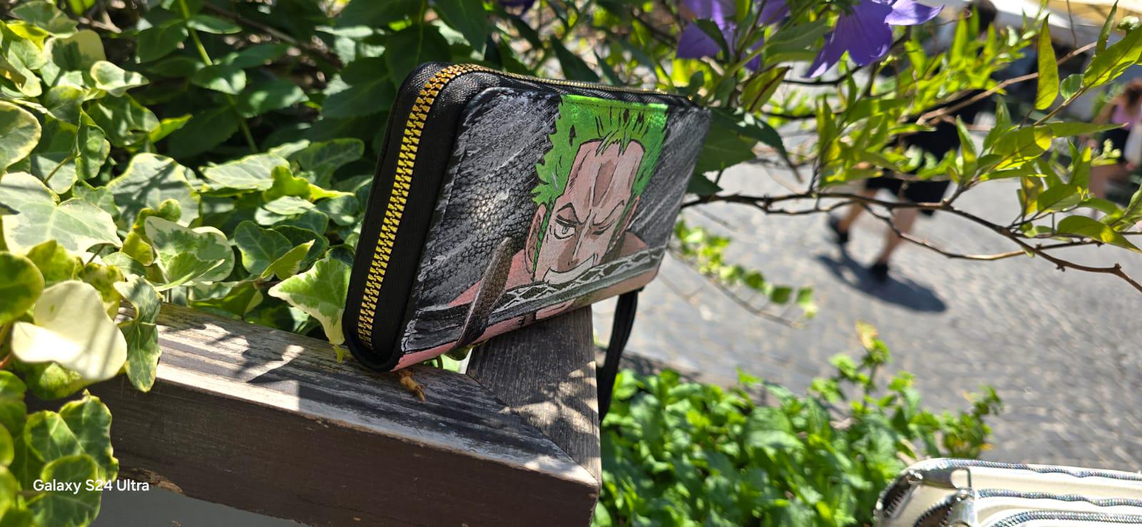 *Portafoglio Dipinto a Mano – Zoro (One Piece) 🏴☠️🎨* Porta con te lo stile dei pirati! Questo *portafoglio in ecopelle dipinto a mano* ha come soggetto principale *Zoro*, uno dei personaggi più amati del celebre anime *One Piece*. Realizzato con *colori acrilici professionali* e sigillato per garantire resistenza nel tempo, è perfetto per fan e collezionisti!
