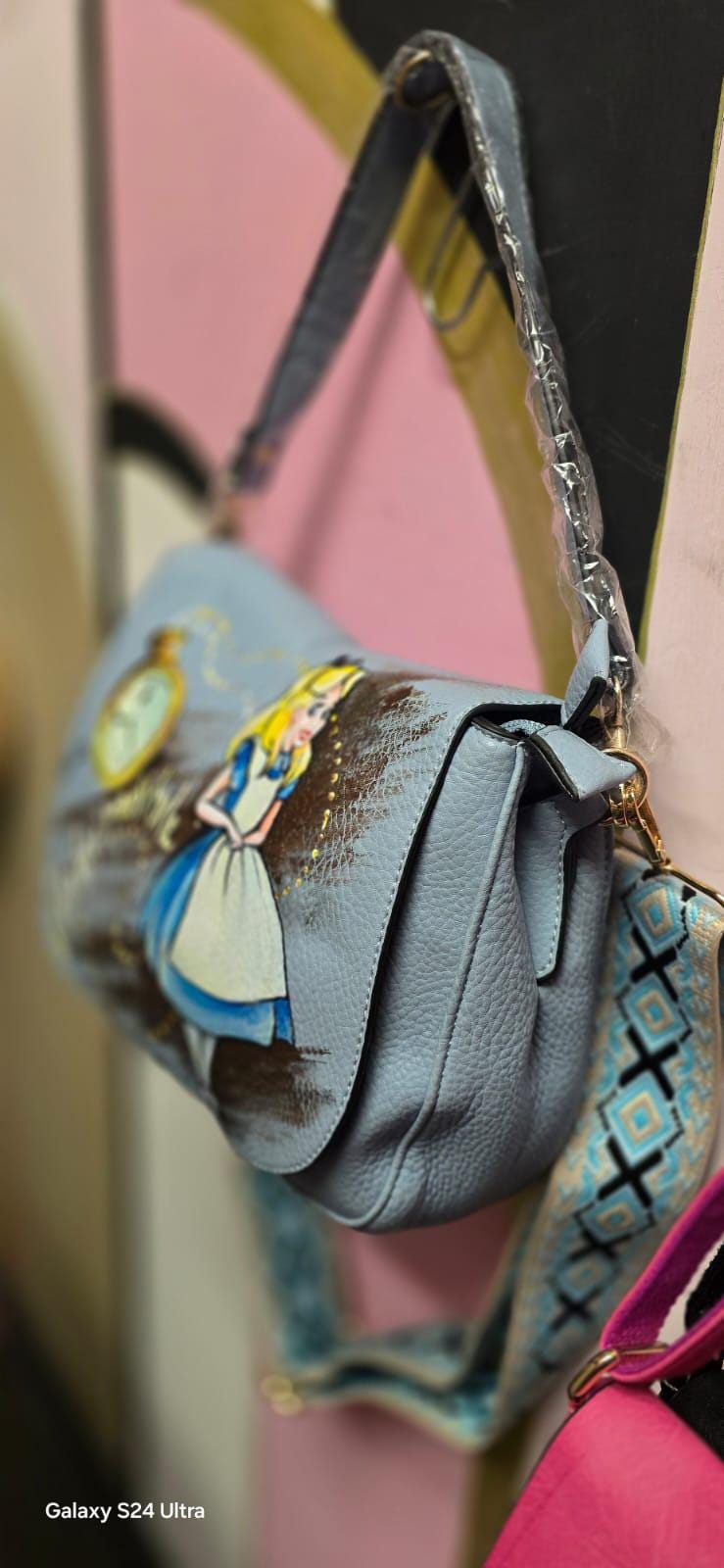 Borsa dipinta a mano "Alice nel Paese delle Meraviglie" - Scritta "Nulla è impossibile" Questa borsa in ecopelle è un'opera unica, realizzata interamente a mano con colori acrilici di alta qualità. Il design rappresenta un omaggio al classico "Alice nel Paese delle Meraviglie", con l'aggiunta della frase "Nulla è impossibile", che conferisce un tocco di magia e ispirazione a ogni outfit. 🧩 *Coordinabile su richiesta:*