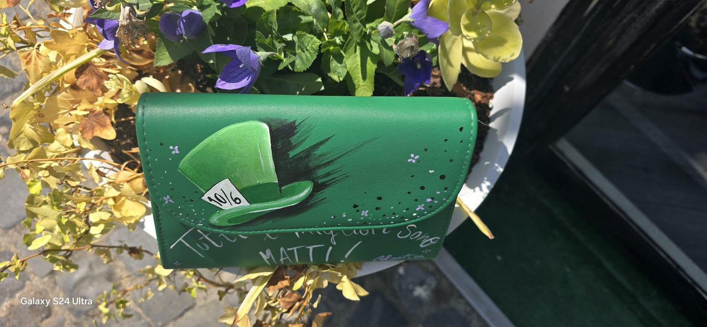 *Borsa Dipinta a Mano – Cappellaio Matto 🎩✨* Un pezzo unico e originale per chi ama il mondo incantato di Alice nel Paese delle Meraviglie! Questa borsa in ecopelle è interamente *dipinta a mano* con colori acrilici professionali e sigillata per durare nel tempo. Il *soggetto principale* è l’iconico *cappello del Cappellaio Matto*, accompagnato dalla celebre frase: *“Tutti i migliori sono matti”*