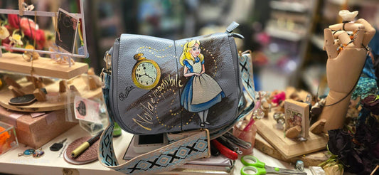 Borsa dipinta a mano "Alice nel Paese delle Meraviglie" - Scritta "Nulla è impossibile" Questa borsa in ecopelle è un'opera unica, realizzata interamente a mano con colori acrilici di alta qualità. Il design rappresenta un omaggio al classico "Alice nel Paese delle Meraviglie", con l'aggiunta della frase "Nulla è impossibile", che conferisce un tocco di magia e ispirazione a ogni outfit. 🧩 *Coordinabile su richiesta:*