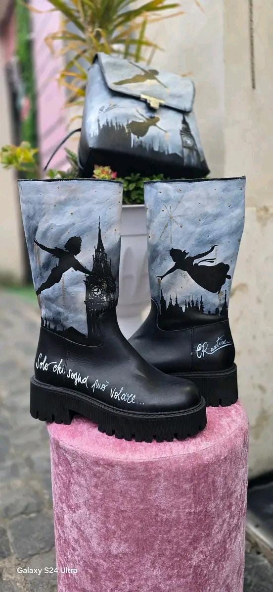 Stivale Dipinto a Mano con Personaggi di Peter Pan - Solo chi sogna può volare 🧩 *Coordinabile su richiesta:* È possibile ordinare *un portafoglio , una borsa o un giacchetto perfettamente abbinato* con lo stesso stile e soggetto ! Aggiungi un tocco di magia al tuo look con questi stivali dipinti a mano, ispirati al mondo incantato di Peter Pan! Ogni paio è realizzato con cura e dettagli, con due personaggi di Peter Pan che volano nel cielo, accompagnati da uno sfondo mozzafiato. La frase "Solo chi sogna p