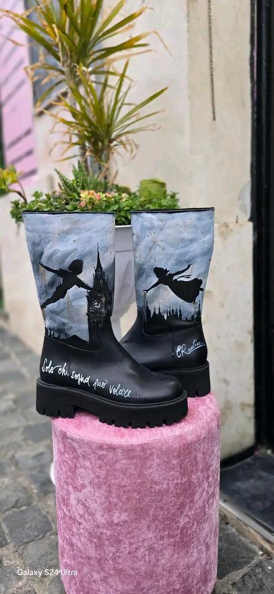 Stivale Dipinto a Mano con Personaggi di Peter Pan - Solo chi sogna può volare 🧩 *Coordinabile su richiesta:* È possibile ordinare *un portafoglio , una borsa o un giacchetto perfettamente abbinato* con lo stesso stile e soggetto ! Aggiungi un tocco di magia al tuo look con questi stivali dipinti a mano, ispirati al mondo incantato di Peter Pan! Ogni paio è realizzato con cura e dettagli, con due personaggi di Peter Pan che volano nel cielo, accompagnati da uno sfondo mozzafiato. La frase "Solo chi sogna p
