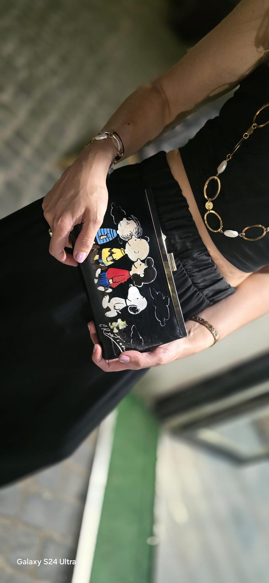 *Borsa Dipinta a Mano – Snoopy &amp; Friends 🐾🎨* Colorata, divertente e dal tocco unico! Questa *borsa in ecopelle* è dipinta interamente a mano e ha come soggetto principale *Snoopy* insieme agli altri personaggi iconici del mondo dei Peanuts. Perfetta per chi ama lo stile originale e vuole portare sempre con sé un tocco di tenerezza e allegria! 👜 *Dettagli del prodotto:* - Materiale: Ecopelle