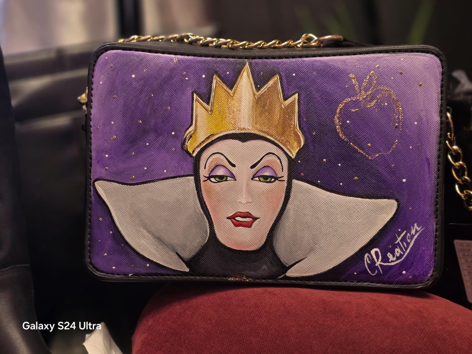 Borsa dipinta a mano ispirata alla Regina Grimilde Materiale: Ecopelle | Misure: 27 cm (lunghezza) x 8 cm (profondità) x 16 cm (altezza) 🧩 *Coordinabile su richiesta:* È possibile ordinare *un portafoglio o un giacchetto perfettamente abbinato* con lo stesso stile e soggetto