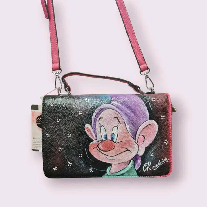 Borsa Dipinta a Mano con Cucciolo dei Sette Nani - Borsa Unica in Ecopelle, Personalizzabile, Regalo per Amanti dei Cartoni 🧩 *Coordinabile su richiesta:* È possibile ordinare *un portafoglio o un giacchetto perfettamente abbinato* con lo stesso stile e soggetto ! Descrizione: Questa borsa dipinta a mano è ispirata al simpatico cucciolo dei Sette Nani, celebre personaggio del cartone animato Biancaneve e i sette nani. Realizzata in ecopelle di alta qualità, la borsa presenta un’illustrazione unica che catt