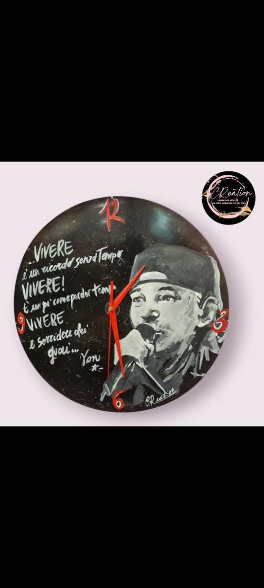 *Orologio da Parete Dipinto a Mano – Vasco Rossi &amp; Frase da "Vivere" 🕒🎶* Un tocco artistico e musicale per la tua casa! Questo *orologio da parete dipinto a mano* è un omaggio all'intramontabile *Vasco Rossi*, con un design unico che unisce il suo volto iconico a una frase tratta dalla canzone *Vivere*. Realizzato con *colori acrilici professionali* su una base di ottima qualità,