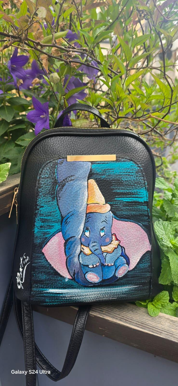 *Borsa Dipinta a Mano – Dumbo 🎨🐘* Un pezzo unico e tenerissimo ispirato al mondo Disney! Questa borsa in ecopelle è *dipinta a mano* con il soggetto principale *Dumbo*, il celebre elefantino volante amato da grandi e piccini. Ogni dettaglio è realizzato a mano con *colori acrilici professionali*, sigillati per garantire durata nel tempo e resistenza al lavaggio fino a 40°. 🖌️ *Dettagli del prodotto*: - Materiale: Ecopelle - Tecnica: Pittura acrilica a mano, con protezione finale - Lavabile in lavatrice (