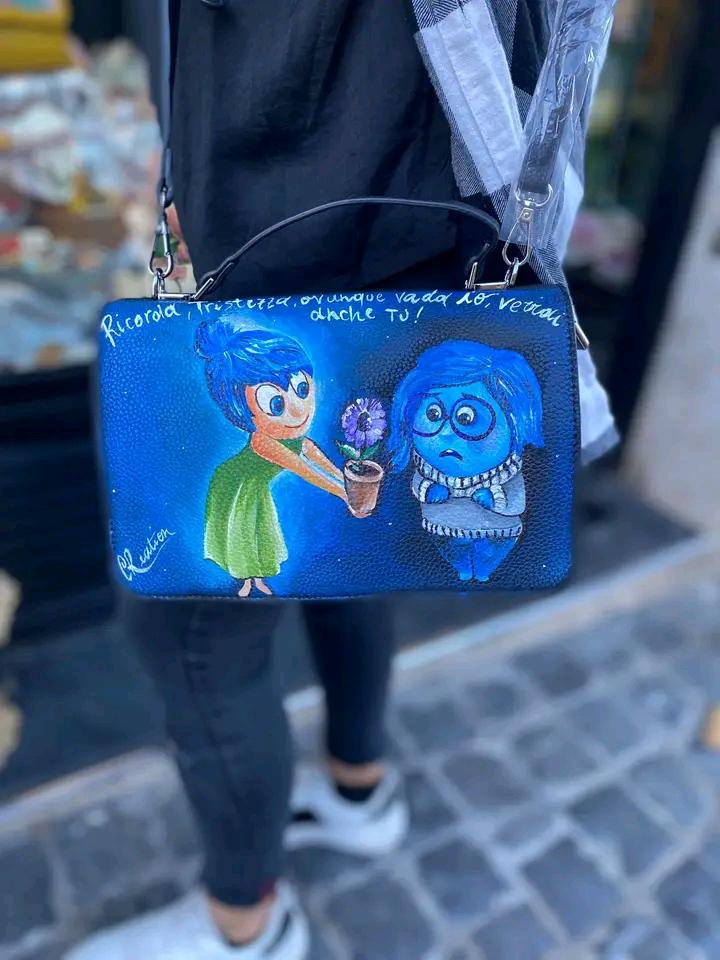 Borsa Dipinta a Mano - Inside Out | Pezzo Unico Artigianale ✨ Un accessorio magico per gli amanti della creatività e delle emozioni! ✨ Questa borsa unica è interamente dipinta a mano con colori acrilici resistenti e raffigura i simpatici e amati personaggi di Inside Out! Perfetta per chi ama il mondo Disney-Pixar e vuole portare sempre con sé un tocco di fantasia e colore. 