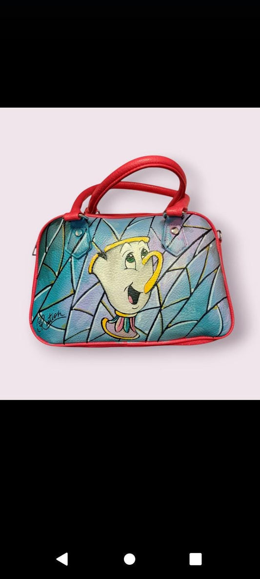 Borsa Dipinta a Mano - Chicco (La Bella e la Bestia) | Accessorio Unico e Magico Porta un po' della magia di La Bella e la Bestia nel tuo guardaroba con questa borsa dipinta a mano, che raffigura Chicco, la dolce e simpatica tazza da tè! Realizzata con colori acrilici di alta qualità, questa borsa è un omaggio al mondo incantato  perfetta per chi ama i personaggi classici e gli accessori
