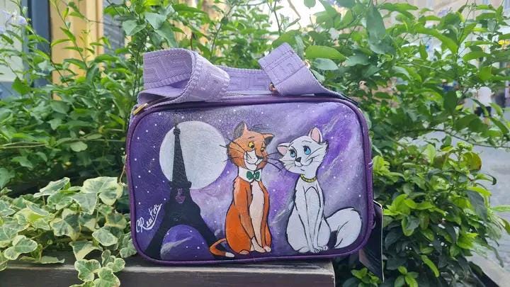 "Borsa Aristogatti dipinta a mano in ecopelle | Lavabile fino a 40°C | Unica e artigianale" 🧩 *Coordinabile su richiesta:* È possibile ordinare *un portafoglio o un giacchetto perfettamente abbinato* con lo stesso stile e soggetto ! Descrizione: Questa borsa artigianale è un omaggio ai dolcissimi Aristogatti! Dipinta a mano con colori acrilici di alta qualità su ecopelle resistente, è l'accessorio perfetto per gli amanti dell'arte e dei classici Disney. La foto mostrata si riferisce a un prodotto già vendu