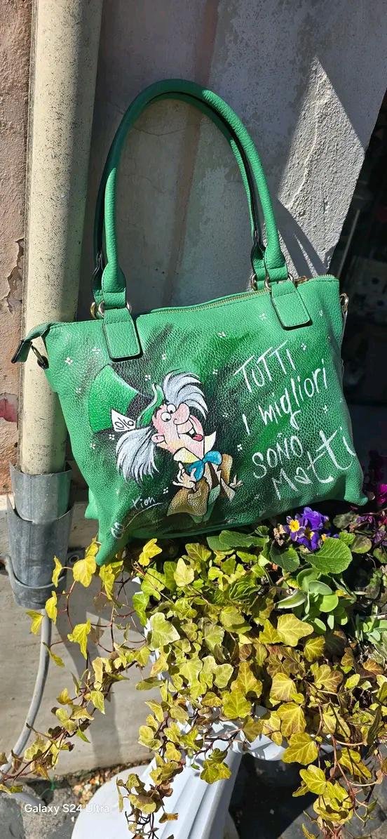 Borsa Dipinta a Mano con Cappellaio Matto - “Tutti i migliori sono matti” - Ecopelle - Personalizzabile 🧩 *Coordinabile su richiesta:* È possibile ordinare *un portafoglio o un giacchetto perfettamente abbinato* con lo stesso stile e soggetto ! Descrizione: Questa borsa dipinta a mano è un omaggio al famoso Cappellaio Matto, personaggio iconico del celebre cartone animato.