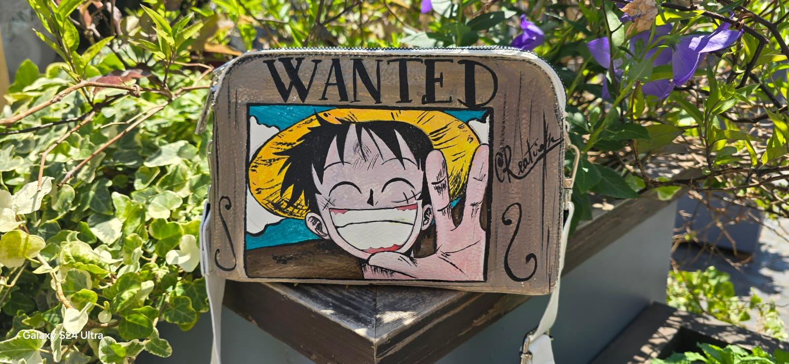 *Borsa Dipinta a Mano – Rubber Cappello di Paglia (One Piece) 🏴☠️🎨* Un accessorio unico per veri fan di One Piece! Questa *borsa in ecopelle dipinta a mano* ha come soggetto principale *Rubber (Luffy)* con il suo iconico *cappello di paglia*, simbolo di libertà e avventura. Realizzata con *colori acrilici professionali*, ogni borsa è un pezzo artigianale unico, perfett