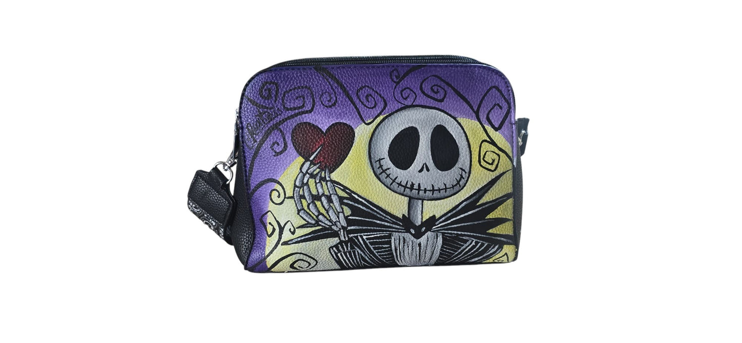 Porta con te il fascino del Re di Halloween con questa borsa in ecopelle, dipinta interamente a mano. Il protagonista è Jack Scheletron, l'iconico personaggio della Città di Halloween, riprodotto con cura nei dettagli per chi ama le atmosfere gotiche e gli accessori che raccontano una storia.