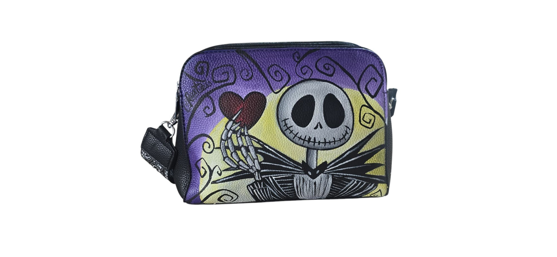 Porta con te il fascino del Re di Halloween con questa borsa in ecopelle, dipinta interamente a mano. Il protagonista è Jack Scheletron, l'iconico personaggio della Città di Halloween, riprodotto con cura nei dettagli per chi ama le atmosfere gotiche e gli accessori che raccontano una storia.